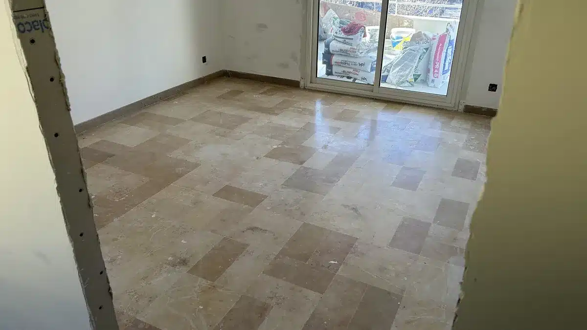 marbre-beige-veine-avant-poncage-appartement-cannes Sol en marbre beige veiné avant rénovation, terne et marqué
