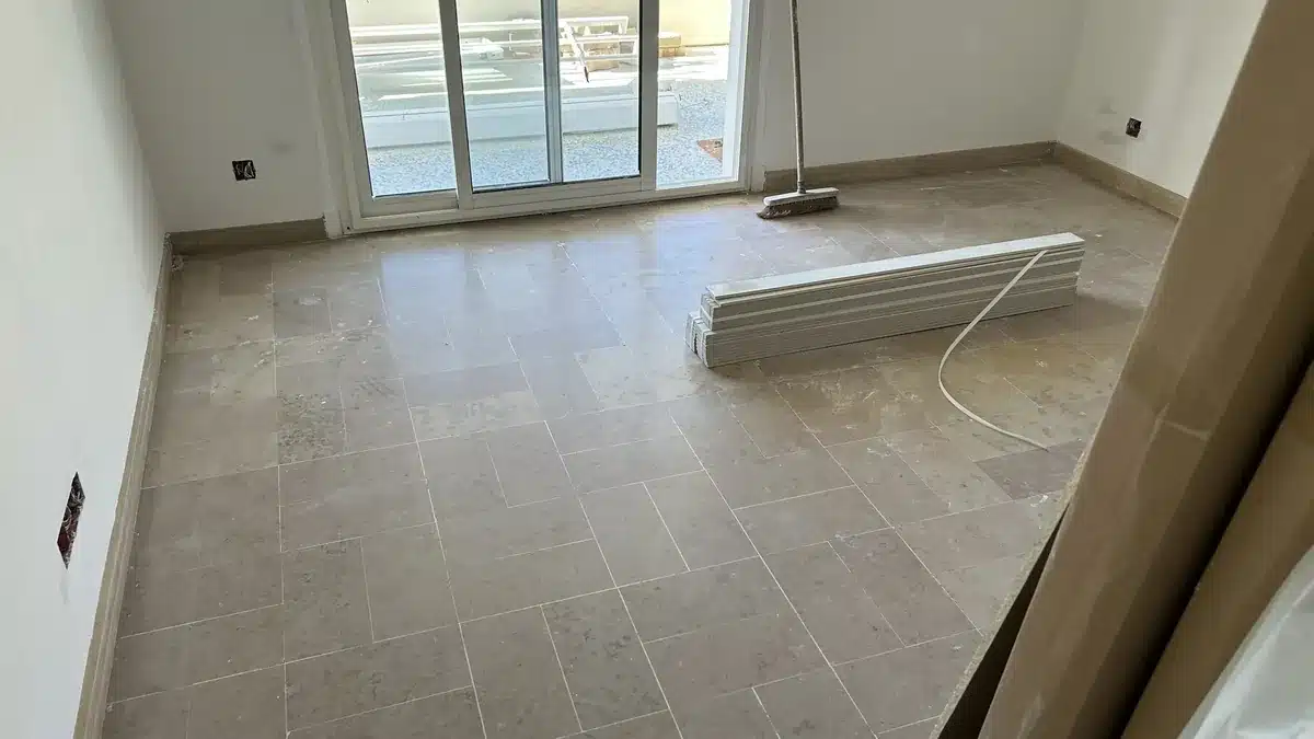 marbre-beige-veine-avant-poncage-piece-appartement-cannes Sol en marbre beige veiné d'une seconde pièce avant rénovation, terne et marqué