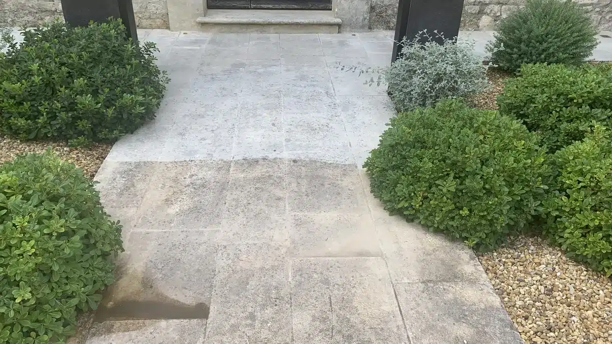 pierre-naturelle-nettoyage-haute-pression-allee-villa-mougins Allée en pierre naturelle d'une villa de Mougins pendant le nettoyage : après le traitement fongicide, le lavage haute pression commence sur la partie du haut, qui est plus claire