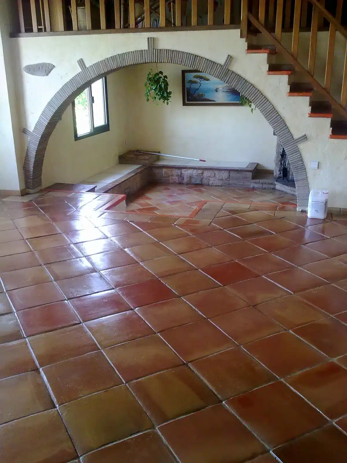 terre-cuite-cire-finition-satinee-arche-banquette-villa-vallauris Séjour d'une villa de Vallauris avec une terre cuite en finition satinée à la cire, devant une arche en pierre apparente et une banquette