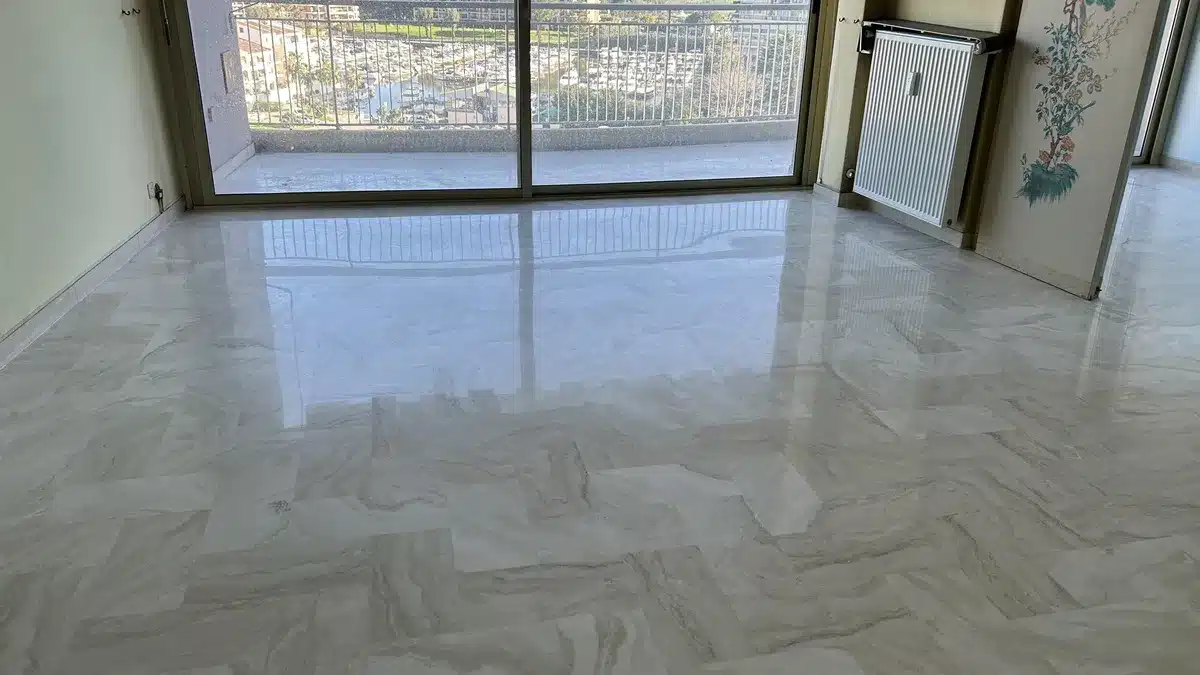 travertin-poli-satine-sejour-mandelieu Séjour d'un appartement de Mandelieu-la-Napoule avec un sol en travertin blanc poli-satiné et vue sur le port